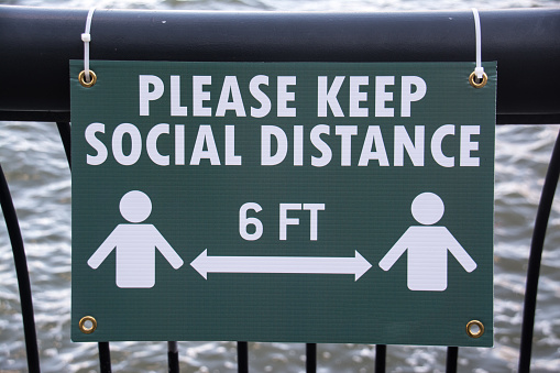 A sign details the importance of keeping 6 feet of social distancing when outdoors