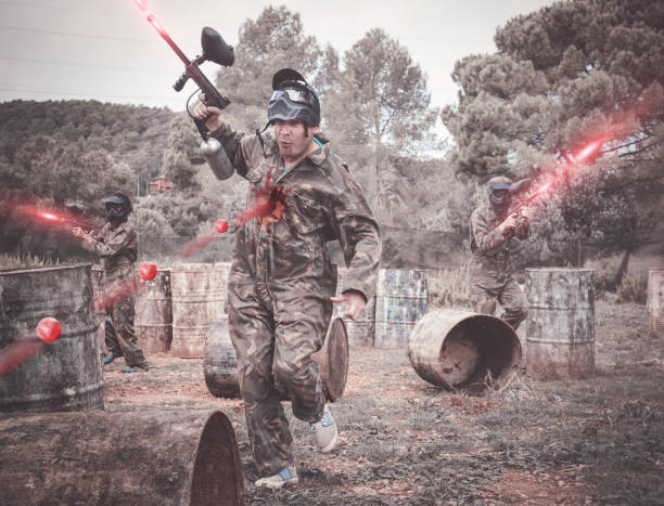 istock Paintball players aiming and shooting with guns 1218676272