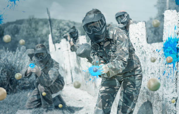 istock Female paintball player aiming in shootout 1218676277