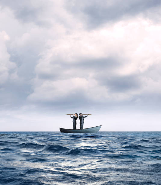 istock Stranded Business People In Boat Search For Help 1218685069