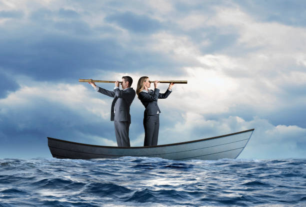 istock Stranded Business People In Boat Search For Help 1218685070
