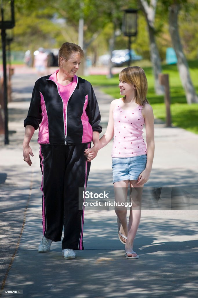 Grandmother Walking with Granddaughter A grandmother and granddaughter walking in a park. Active Lifestyle Stock Photo
