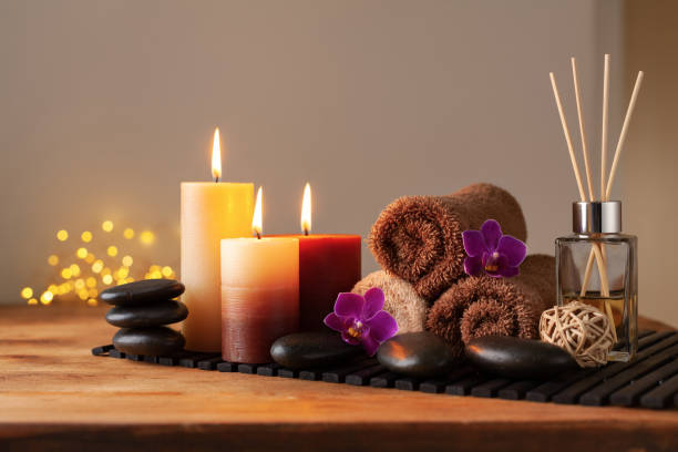 spa, beauty treatment and wellness background with massage stone, orchid flowers, towels and burning candles. - beauty spa spa treatment health spa orchid imagens e fotografias de stock