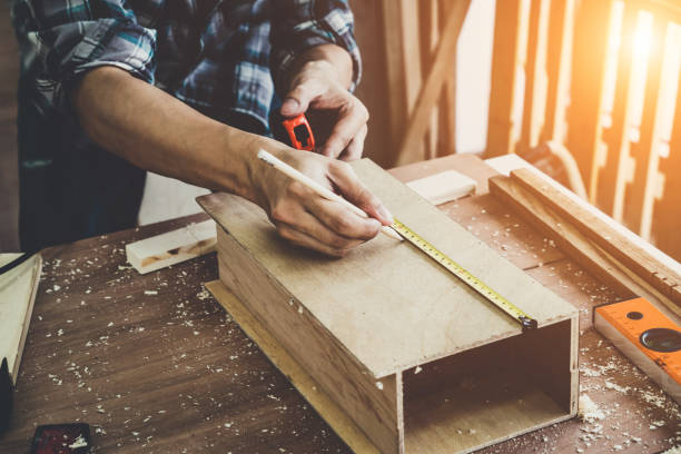 istock Carpenter working on wood craft at workshop to produce construction material or wooden furniture. The young Asian carpenter use professional tools for crafting. DIY maker and carpentry work concept. 1218694266