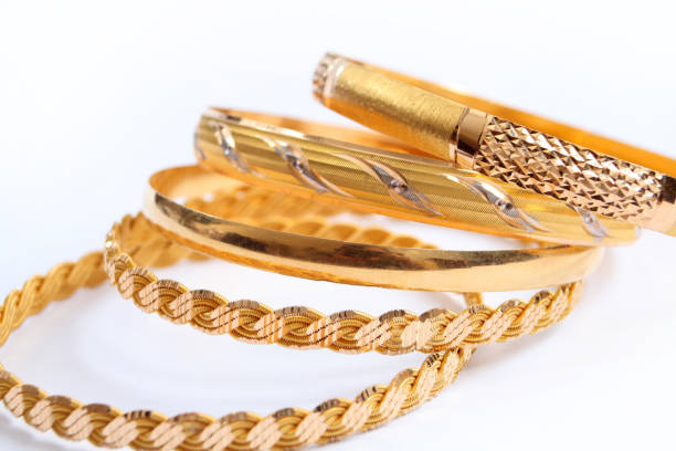 istock various gold bracelets on a white background 1218697934