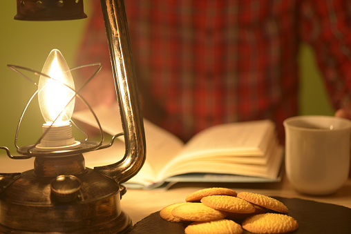 Man reading with lantern light