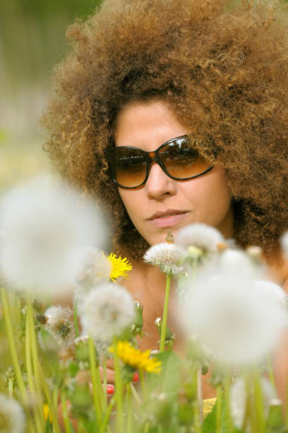 istock Relaxing Woman In A Dandelion Field 1218703841