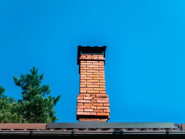 istock Brick chimney pipe against a blue sky. 1218703844