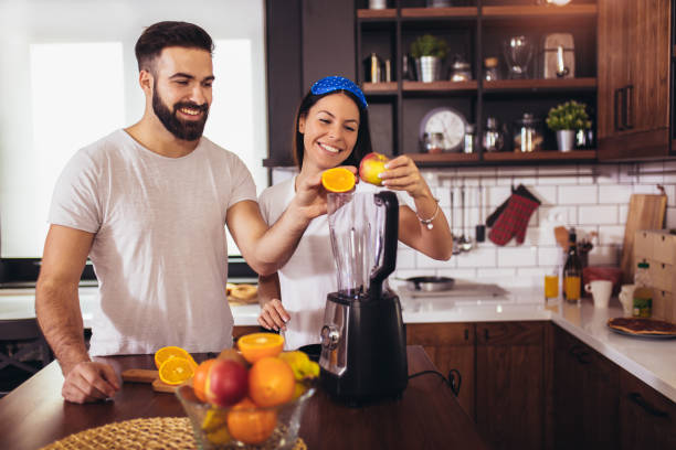 istock Couple making fresh organic juice in kitchen together 1218704007