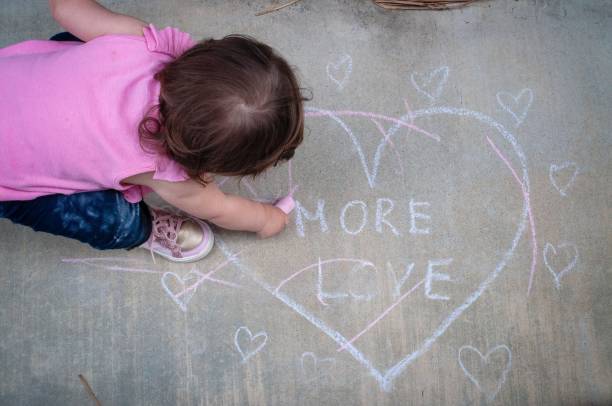 istock Girl drawing with chalk on the sidewalk 1218705254