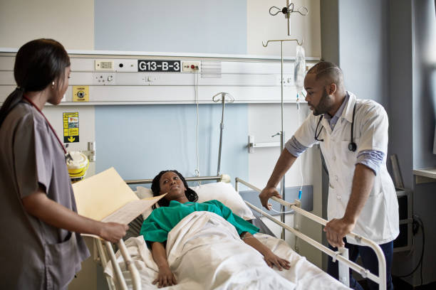 istock Young African Nurse and Medical Student Talking with Patient 1218705964