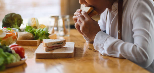 istock a female chef cooking and eating a whole wheat sandwich in kitchen 1218706470