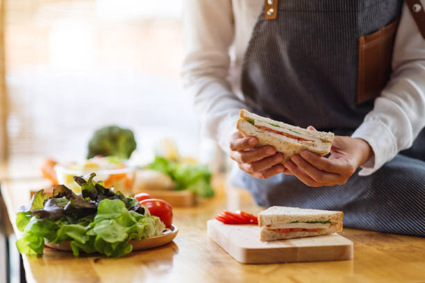 istock a female chef cooking and hloding a whole wheat sandwich in kitchen 1218706541