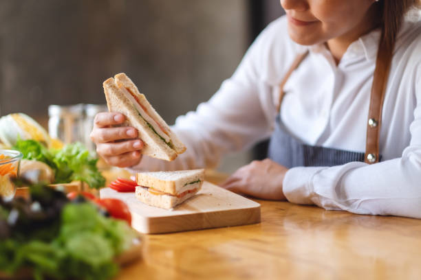 istock a female chef cooking and eating a whole wheat sandwich in kitchen 1218706543