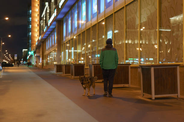 Moscow, Russia - April 11, 2020:: Young woman walking with dog.. Concepts - Stay at home, save live. Concepts of social distancing, self-isolation. Coronavirus Pandemic lifestyles