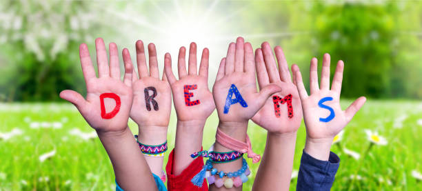istock Kids Hands Holding Word Dreams, Grass Meadow 1218707845