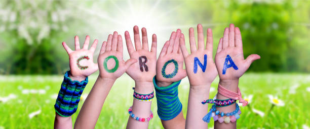istock Children Hands Building Word Corona, Grass Meadow 1218708098