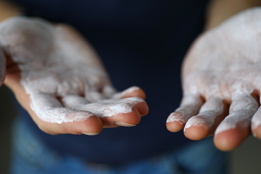 Male hands smeared with magnesium powder ready to workout close-up