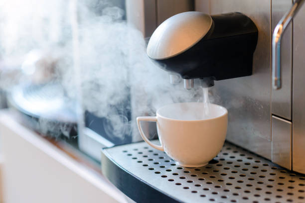 istock White cup standing on grating of automatic coffee maker machine. Coffee break concept 1218712014