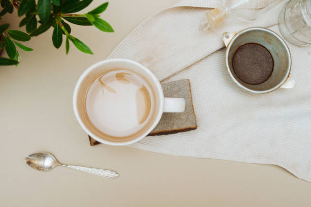 istock Cozy home workplace for remote work during isolation and quarantine with a Cup of tea on a natural stone stand, a green house plant, vintage metal spoon, top view 1218712860