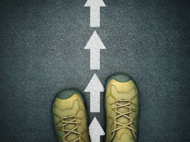 istock Feet on Asphalt Road with Arrows - 3D Rendering 1218713253