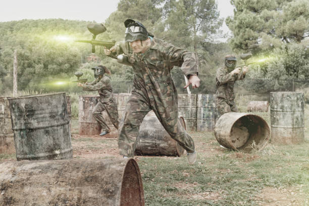 istock Paintball players aiming and shooting with guns 1218714490