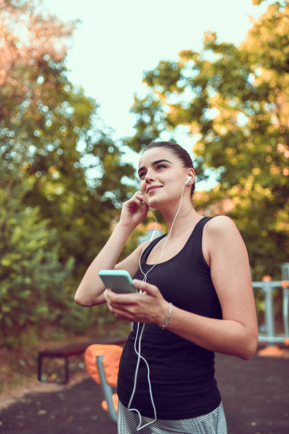 istock Cute Female And Her Smartphone Playlist During Outdoor Training 1218714493