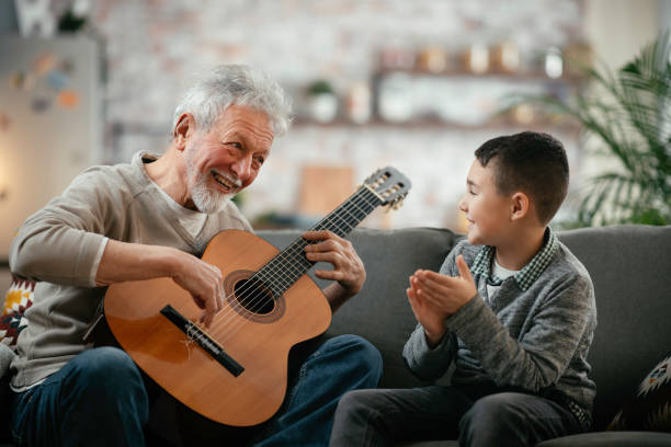 istock Grandfather and grandson playing guitar. 1218715545