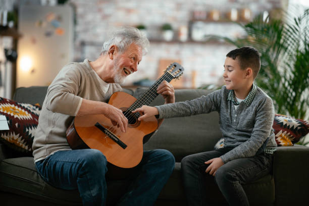 istock Grandfather and grandson playing guitar. 1218716315