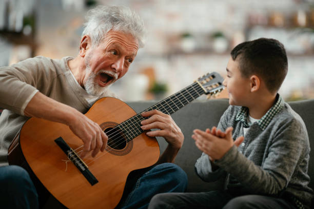 istock Grandfather and grandson playing guitar. 1218716444