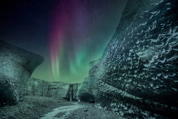 istock Northern lights aurora borealis over glacier ice cave. 1218717970