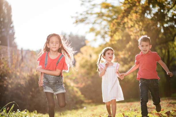 istock Happy kids running and playing in public park 1218718261