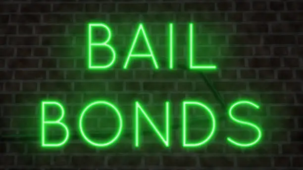Neon sign for BAIL BONDS on a wall at night