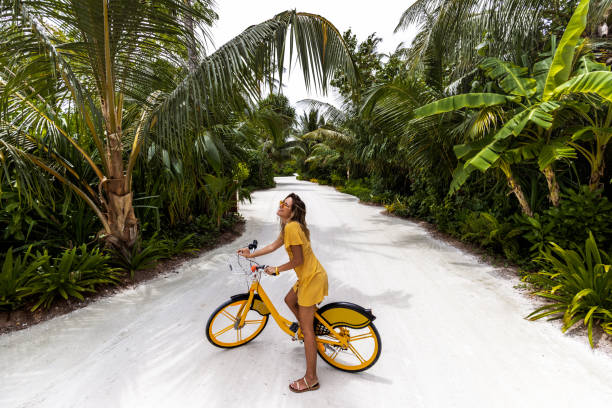 femme heureux ayant l’amusement sur un vélo dans la nature. - maldives photos et images de collection