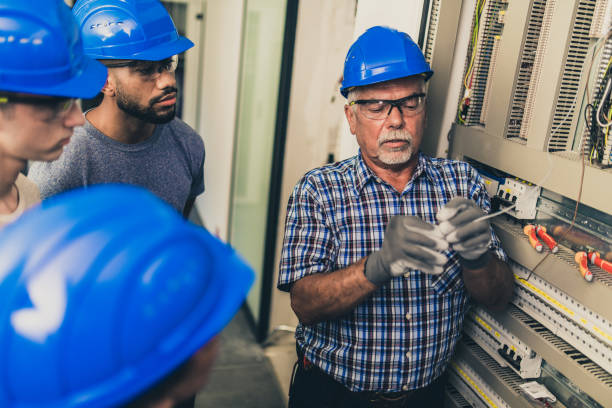 istock Electrician teaching his apprentices how to strip the wires 1218720403