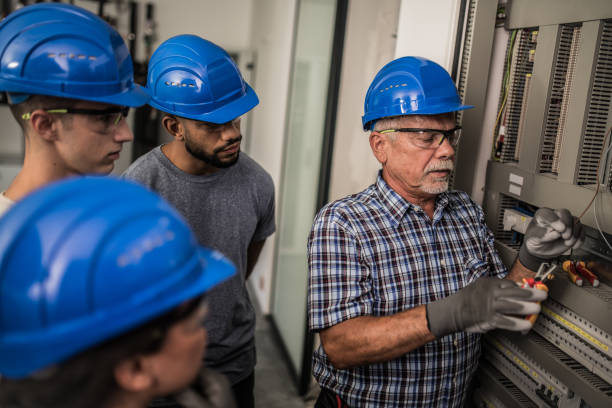 istock Electrician teaching his apprentices how to strip the wires 1218720408
