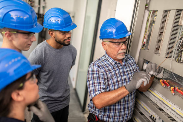 istock Electrician teaching his apprentices how to strip the wires 1218720412