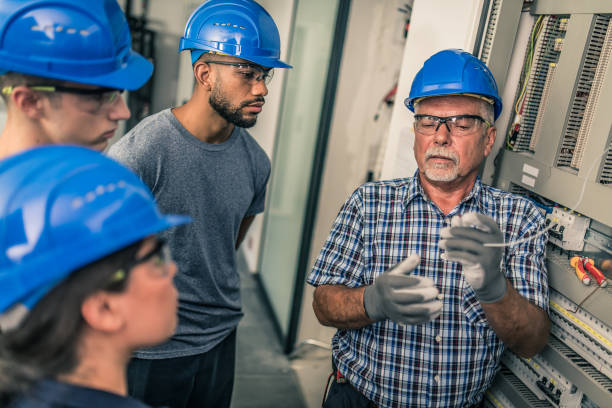 istock Electrician teaching his apprentices how to strip the wires 1218720416