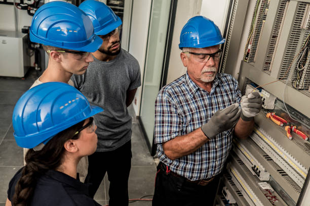 istock Electrician teaching his apprentices how to strip the wires 1218720421