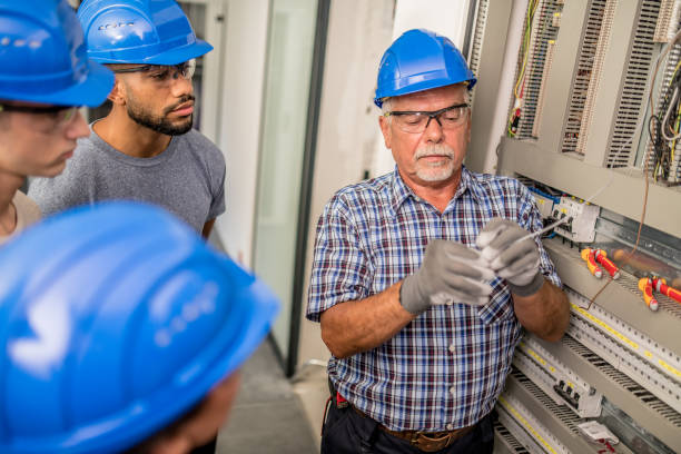 istock Electrician teaching his apprentices how to strip the wires 1218720443