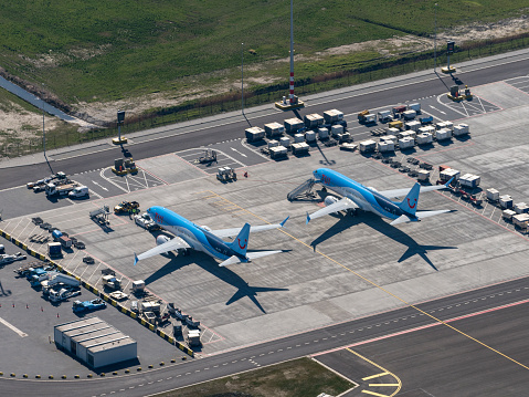 Amsterdam, Holland, March 25, 2020. Jet airplanes are grounded due to government regulations. These blue aircrafts of travel agency TUI are parked at Schiphol gate.