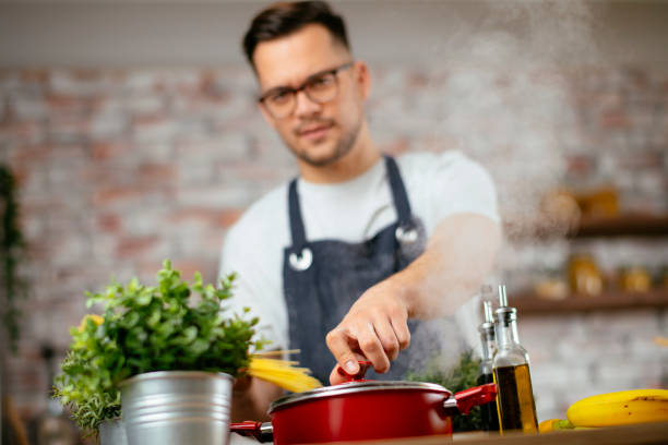 istock Young handsome man making delicious food in kitchen. 1218721706