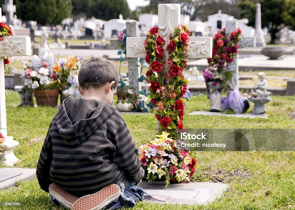 Giovane ragazzo in ginocchio in una tomba in lutto - Foto stock royalty-free di Bambini maschi