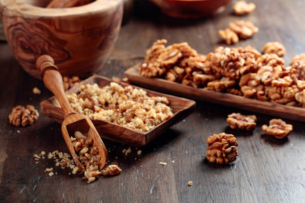 istock Walnuts in a wooden dish on an old wooden table. 1218723102