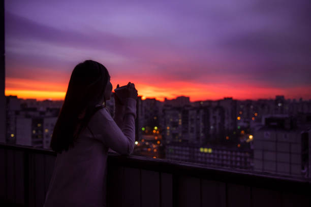 istock young woman drinking tea and watching the sunset. 1218723127