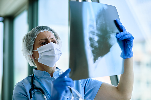 Doctora que examina la radiografía de tórax de la paciente en el hospital. photo
