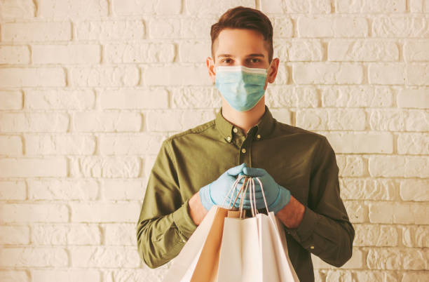 istock Hipster man courier with shopping bags in hands 1218726548