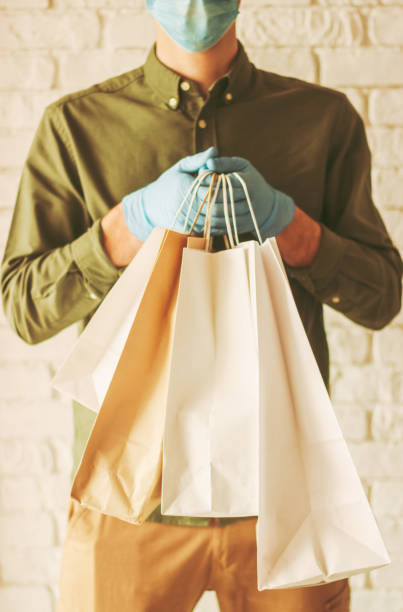 istock Delivery guy courier holding shopping bags in hands 1218726632