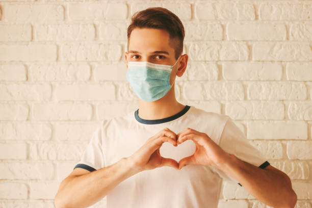 istock Doctor in protective mask gesturing love heart sign 1218726870
