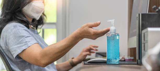 Covid-19 outbreak, coronavirus pandemic prevention with woman with n95 face mask cleaning hand with alcohol gel sanitizer during work at home quarantine for hygience antibacteria safety brote de covid-19, prevención de pandemia de coronavirus con mujer con n95 mano de limpieza de máscaras faciales con desinfectante de gel de alcohol durante el trabajo en cuarentena en casa para la seguridad de las antibacterias de higiene